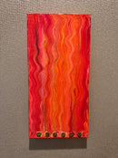 Rectangular red and orange wavy patterned object on a gray background