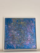 A square framed abstract painting featuring swirling, marbled textures in shades of blue, purple, pink, and hints of gold, displayed against a plain off-white wall.
